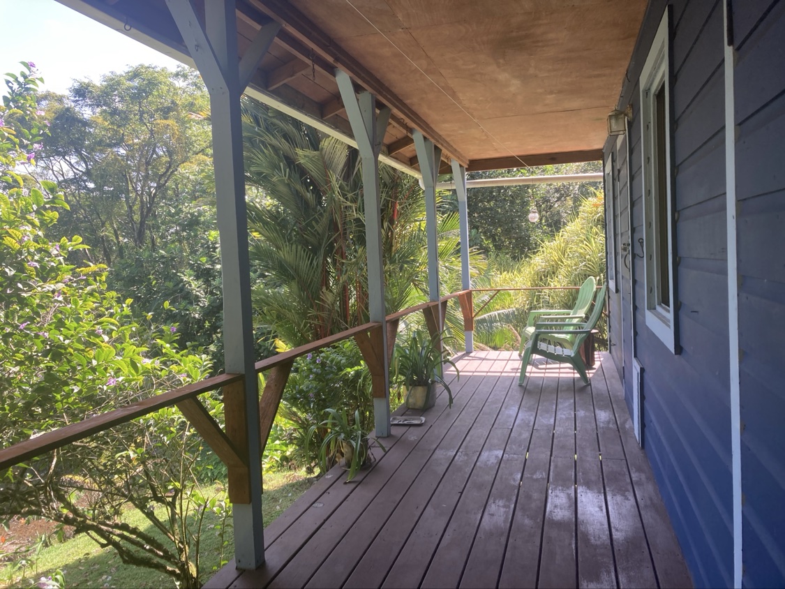 The casita's private wooden porch with chairs, surrounded by jungle