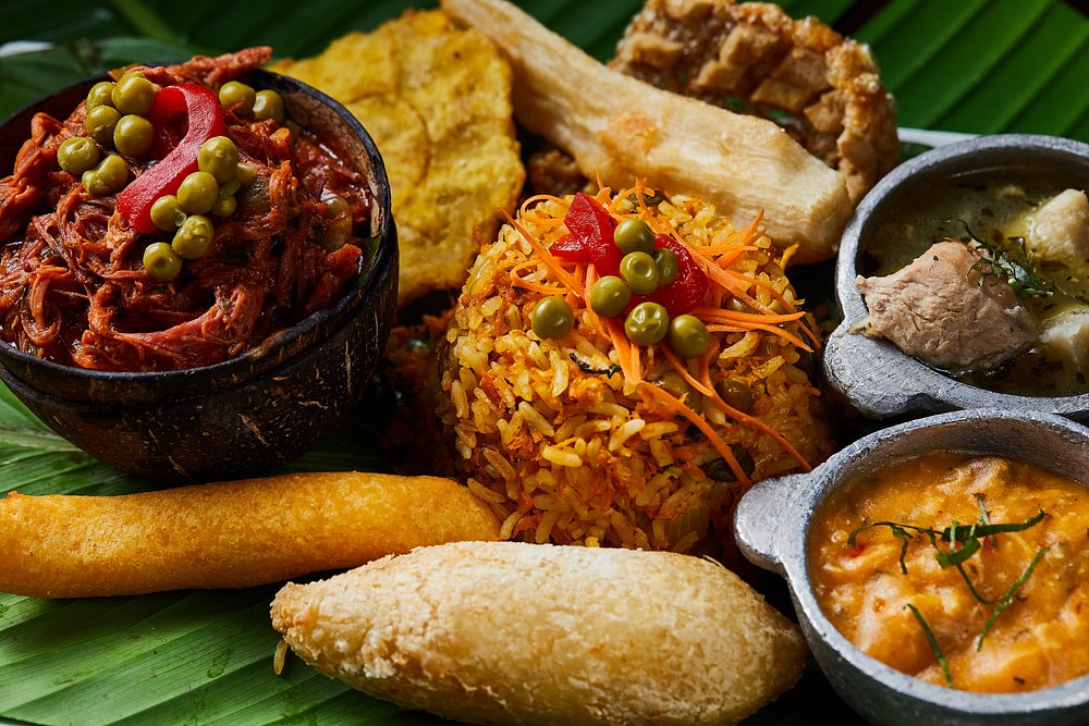 A Panamanian sampler served on a banana leaf — shredded beef, seasoned rice, fried plantain, yuca and a stuffed carimañola